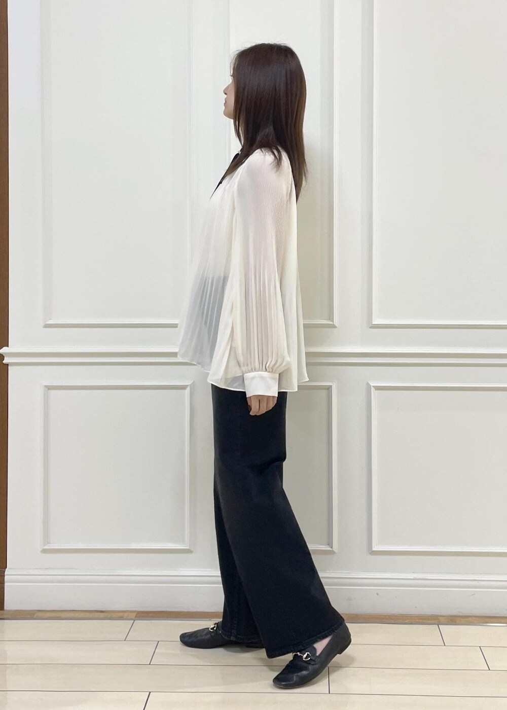 ホワイト系のショルダーバッグ、ブラック系のデニムパンツを着用したレディースの秋コーディネートの3枚目の写真