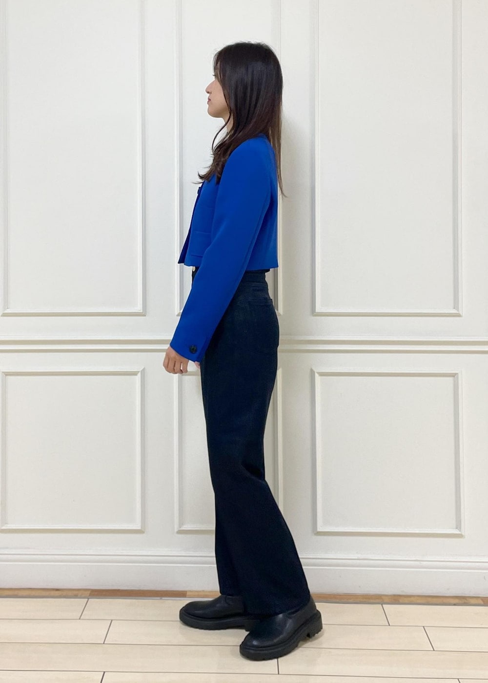 ブルー系のデニムパンツ、ホワイト系のハンドバッグ、ブルー系のノーカラージャケットを着用したレディースの秋コーディネートの3枚目の写真