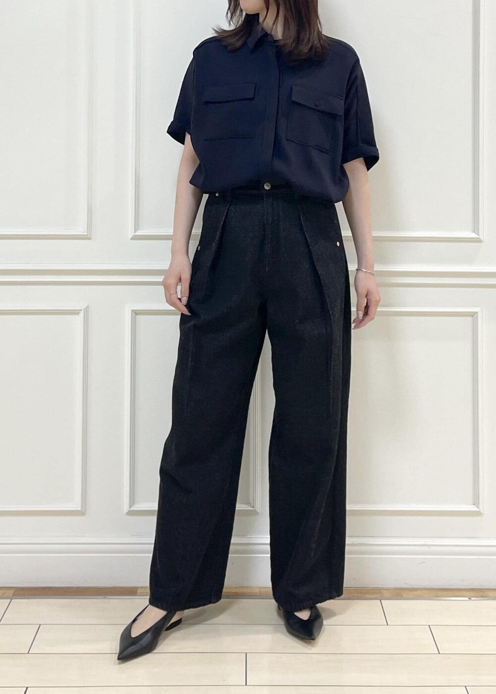 ブラック系のデニムパンツ、ベージュ系のショルダーバッグ、ブルー系のニット/セーターを着用したレディースの春コーディネートの10枚目の写真