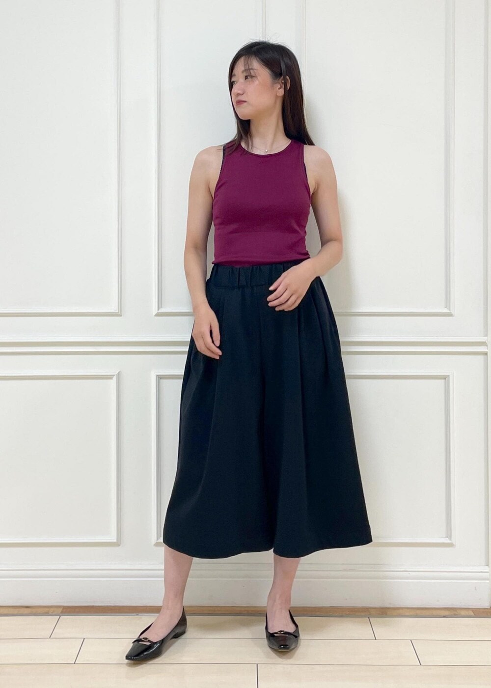 レッド系のタンクトップ、ベージュ系のショルダーバッグ、ブラック系のその他パンツを着用したレディースの夏コーディネートの5枚目の写真