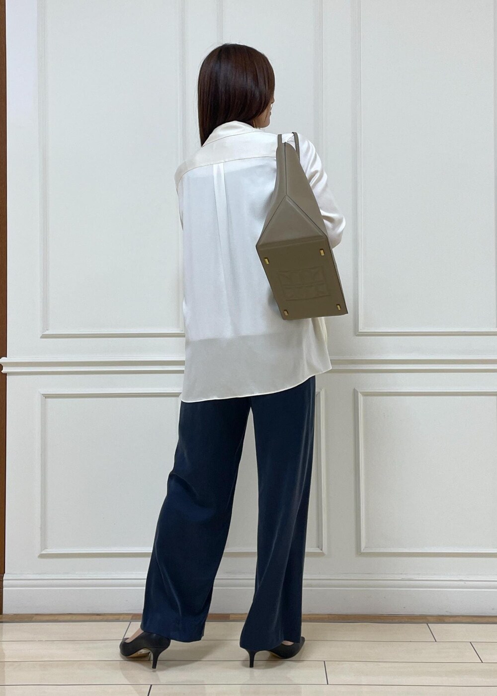 ブラック系のパンプス、ベージュ系のキャミソール、ホワイト系のシャツ/ブラウスを着用したレディースの春コーディネートの3枚目の写真