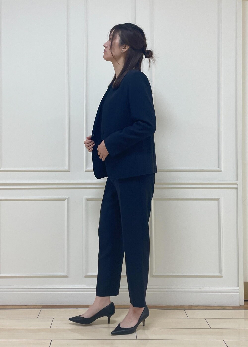 ブラック系のハンドバッグ、ブラック系のパンプス、ブルー系のその他パンツを着用したレディースの冬コーディネートの2枚目の写真