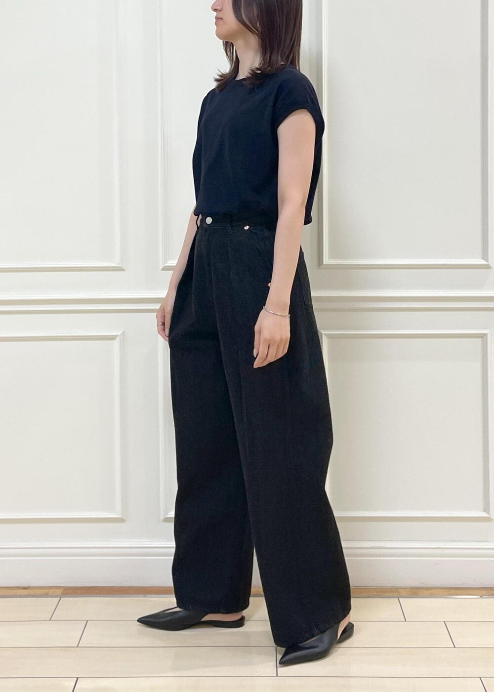 ブラック系のデニムパンツ、ベージュ系のショルダーバッグ、ブルー系のニット/セーターを着用したレディースの春コーディネートの3枚目の写真