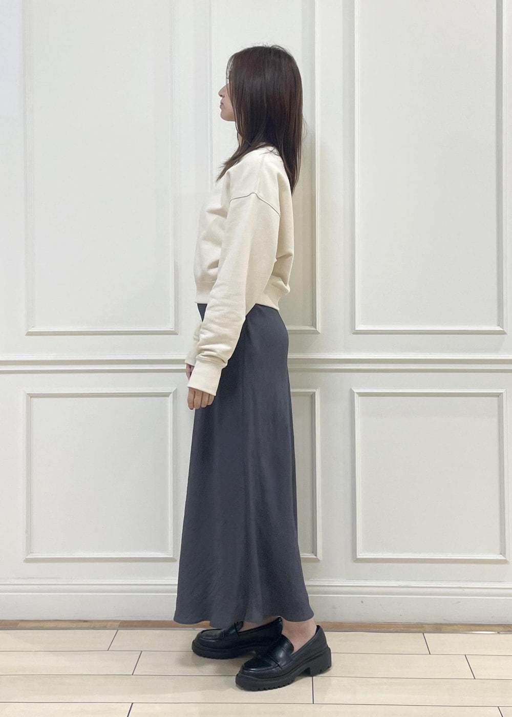 ブルー系のトートバッグ、グレー系のスカート、ベージュ系のスウェットを着用したレディースの秋コーディネートの4枚目の写真