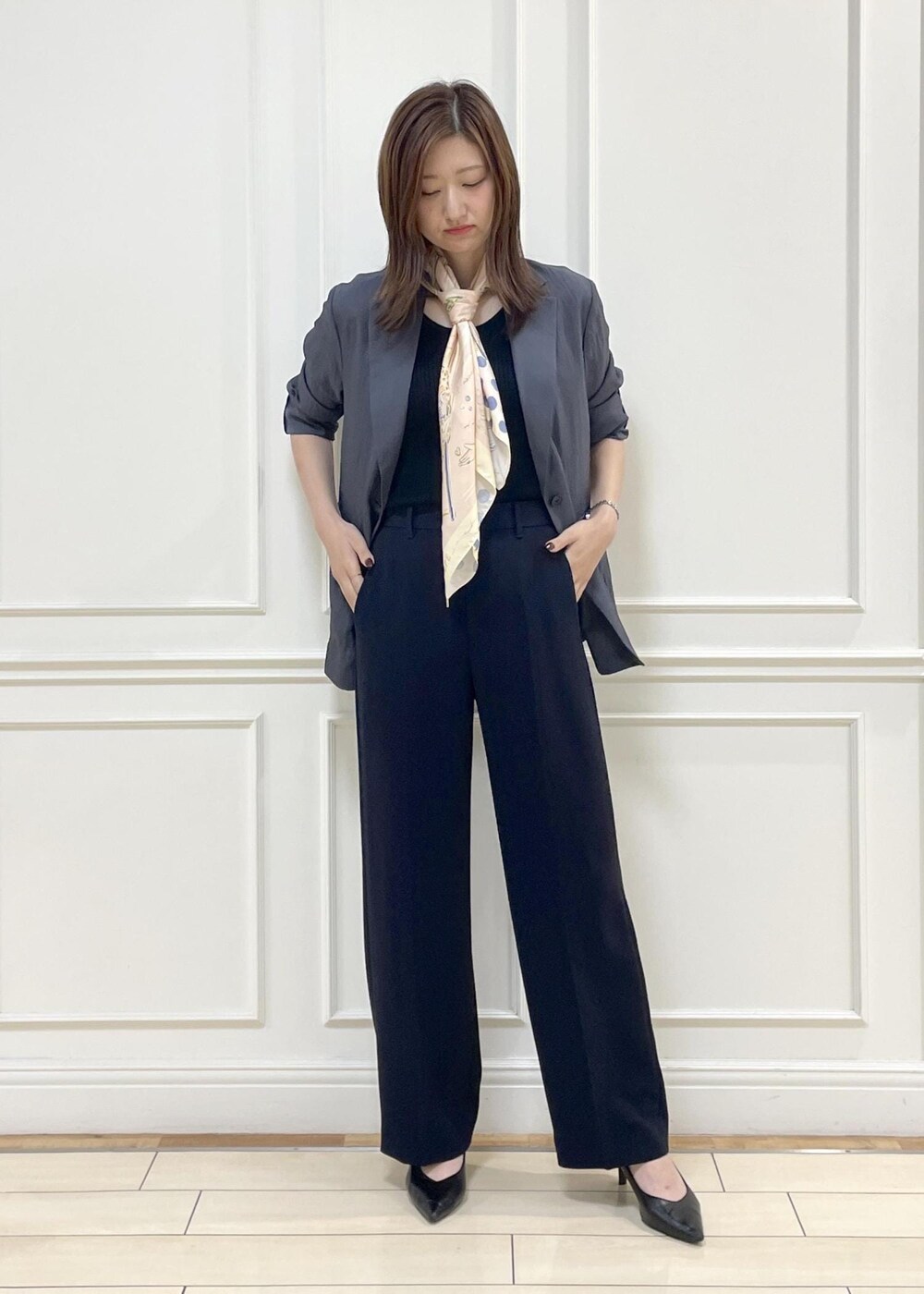 ホワイト系のトートバッグ、グレー系のテーラードジャケット、グレー系のニット/セーターを着用したレディースの秋コーディネートの2枚目の写真