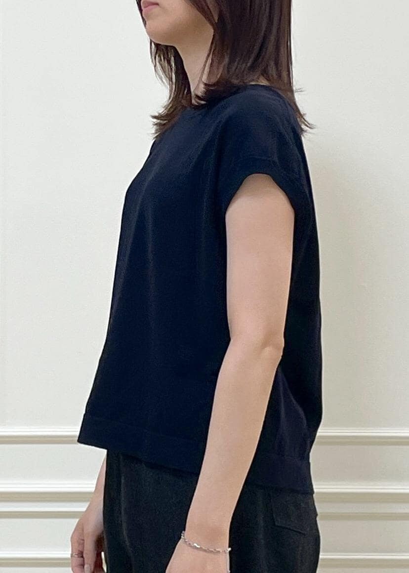 ブラック系のデニムパンツ、ベージュ系のショルダーバッグ、ブルー系のニット/セーターを着用したレディースの春コーディネートの4枚目の写真