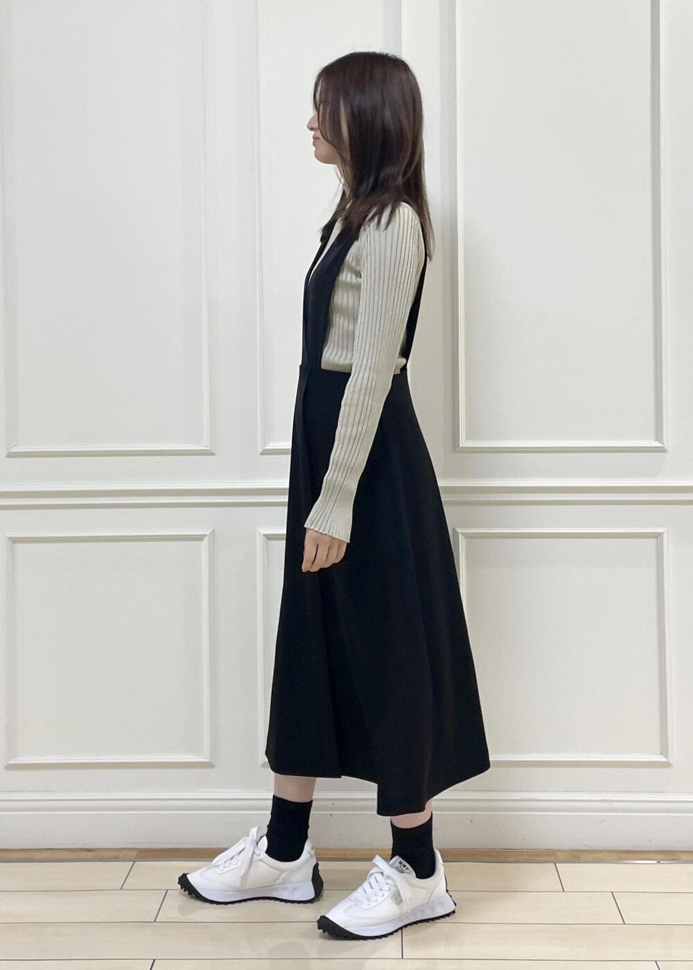 ブラック系のワンピース、ベージュ系のニット/セーター、イエロー系のハンドバッグを着用したレディースの秋コーディネートの2枚目の写真