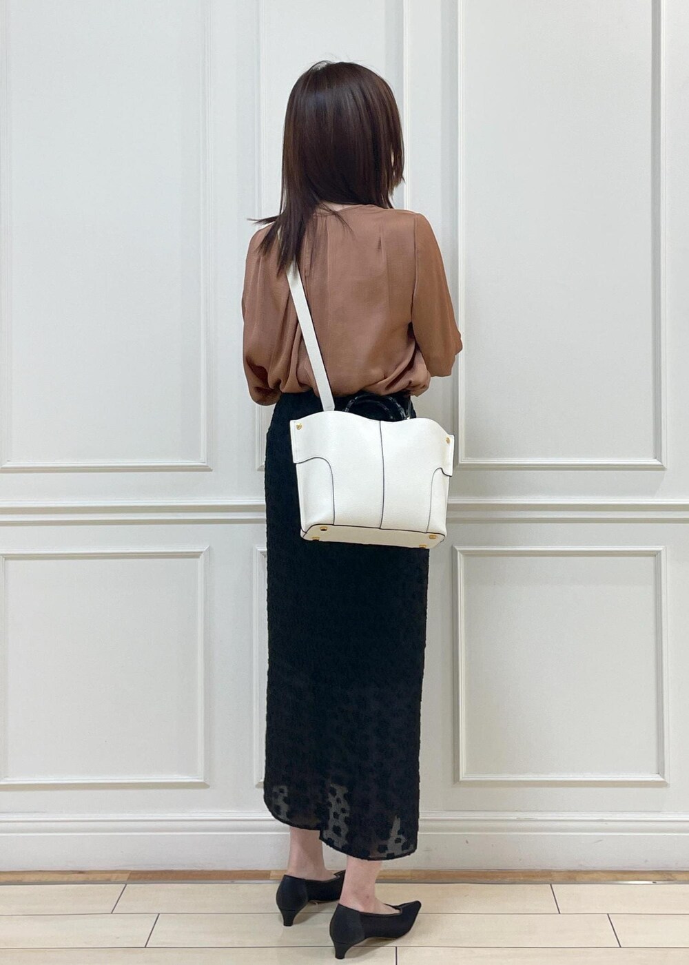 ブラック系のスカート、ホワイト系のハンドバッグ、レッド系のシャツ/ブラウスを着用したレディースの夏コーディネートの7枚目の写真