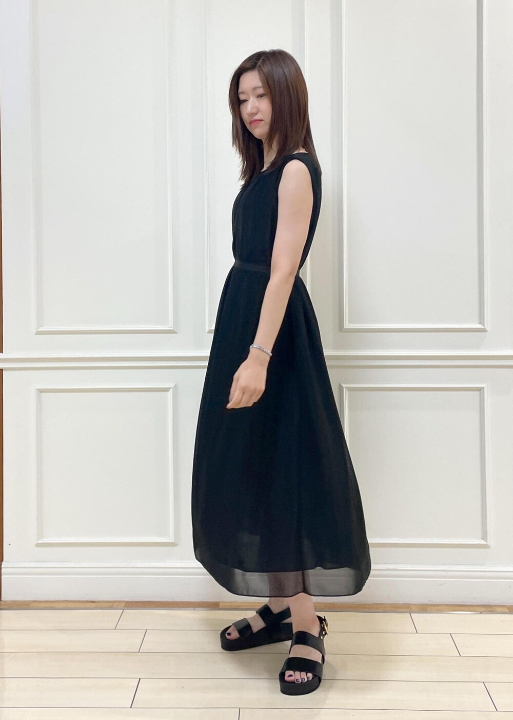 ブラック系のショルダーバッグ、ブラック系のサンダル、ブラック系のワンピースを着用したレディースの夏コーディネートの5枚目の写真