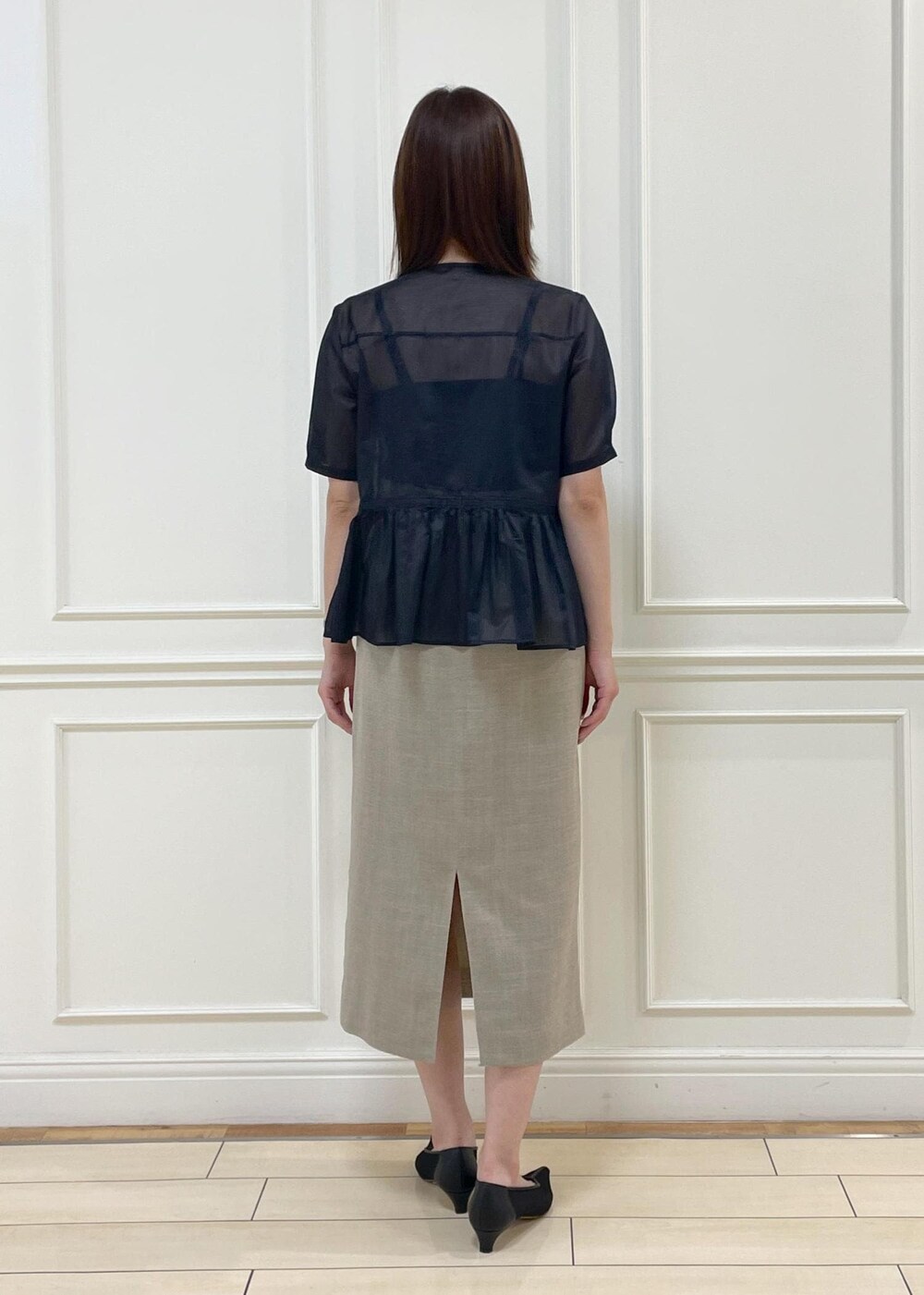 ブラック系のハンドバッグ、ベージュ系のスカート、ブルー系のシャツ/ブラウスを着用したレディースの夏コーディネートの3枚目の写真