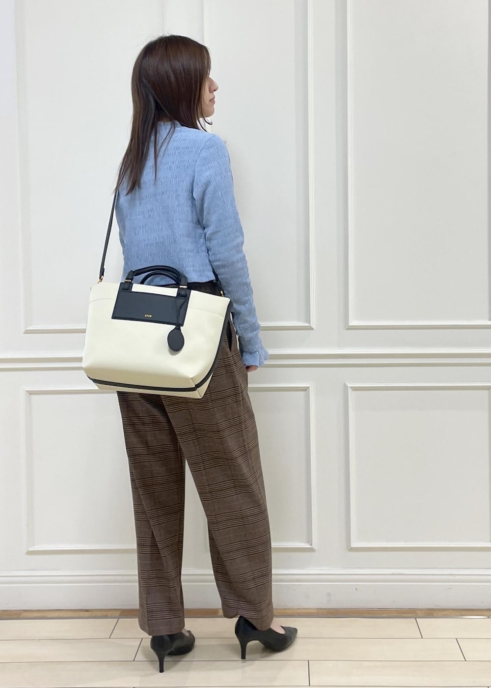 ホワイト系のトートバッグ、ブラウン系のその他パンツ、ブルー系のTシャツ/カットソーを着用したレディースの冬コーディネートの9枚目の写真