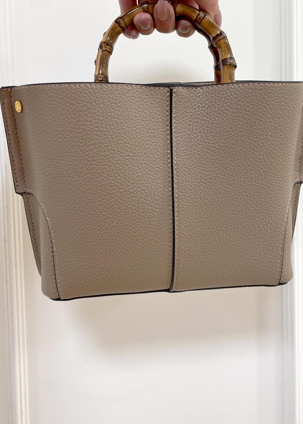 レッド系のニット/セーター、ブラック系のスカート、ベージュ系のハンドバッグを着用したレディースの秋コーディネートの8枚目の写真