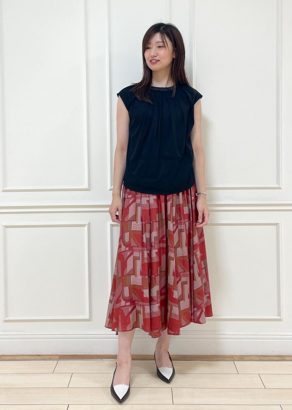 ブラック系のパンプス、レッド系のスカート、ブラック系のTシャツ/カットソーを着用したレディースの夏コーディネートの5枚目の写真