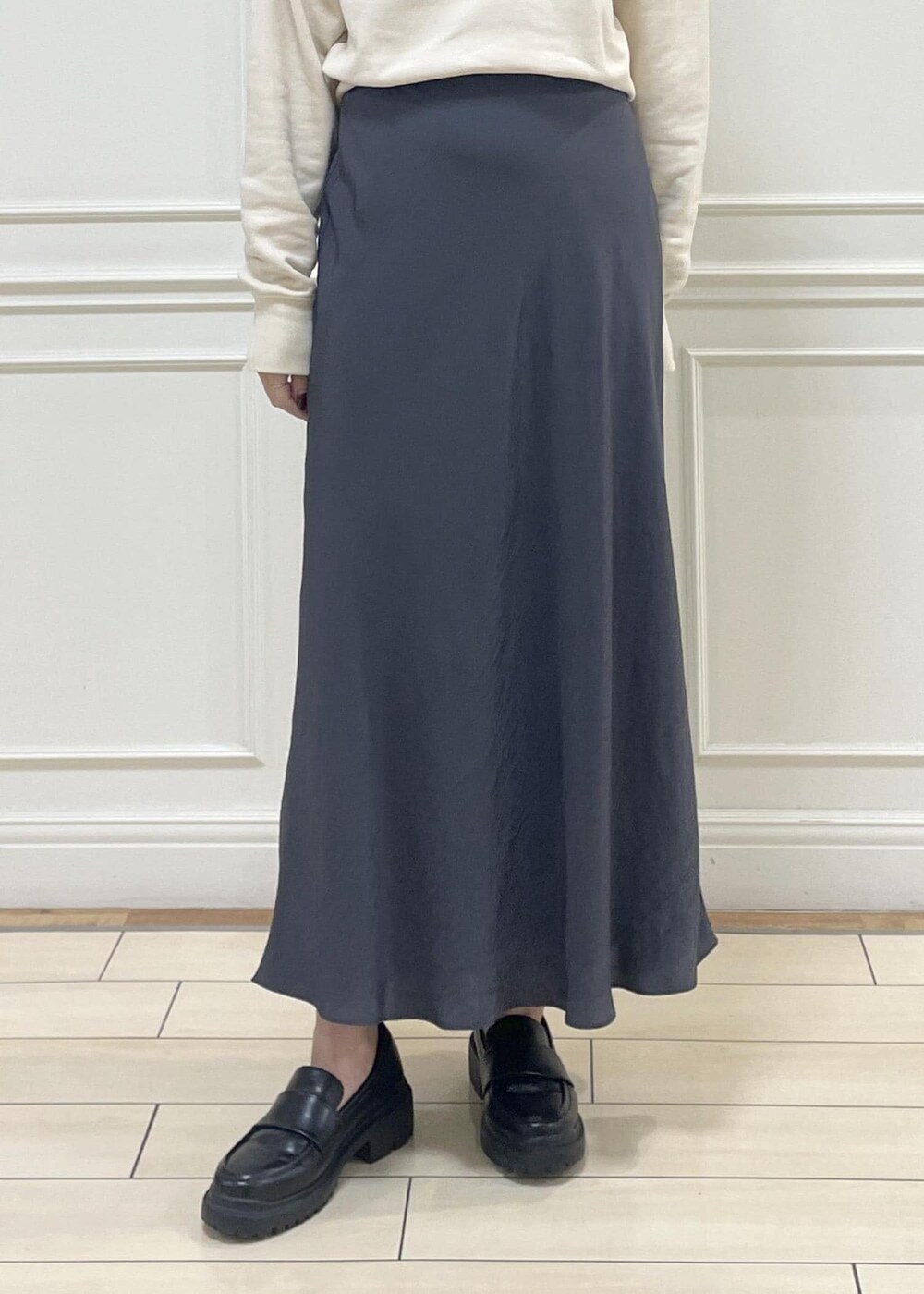 ブルー系のトートバッグ、グレー系のスカート、ベージュ系のスウェットを着用したレディースの秋コーディネートの6枚目の写真