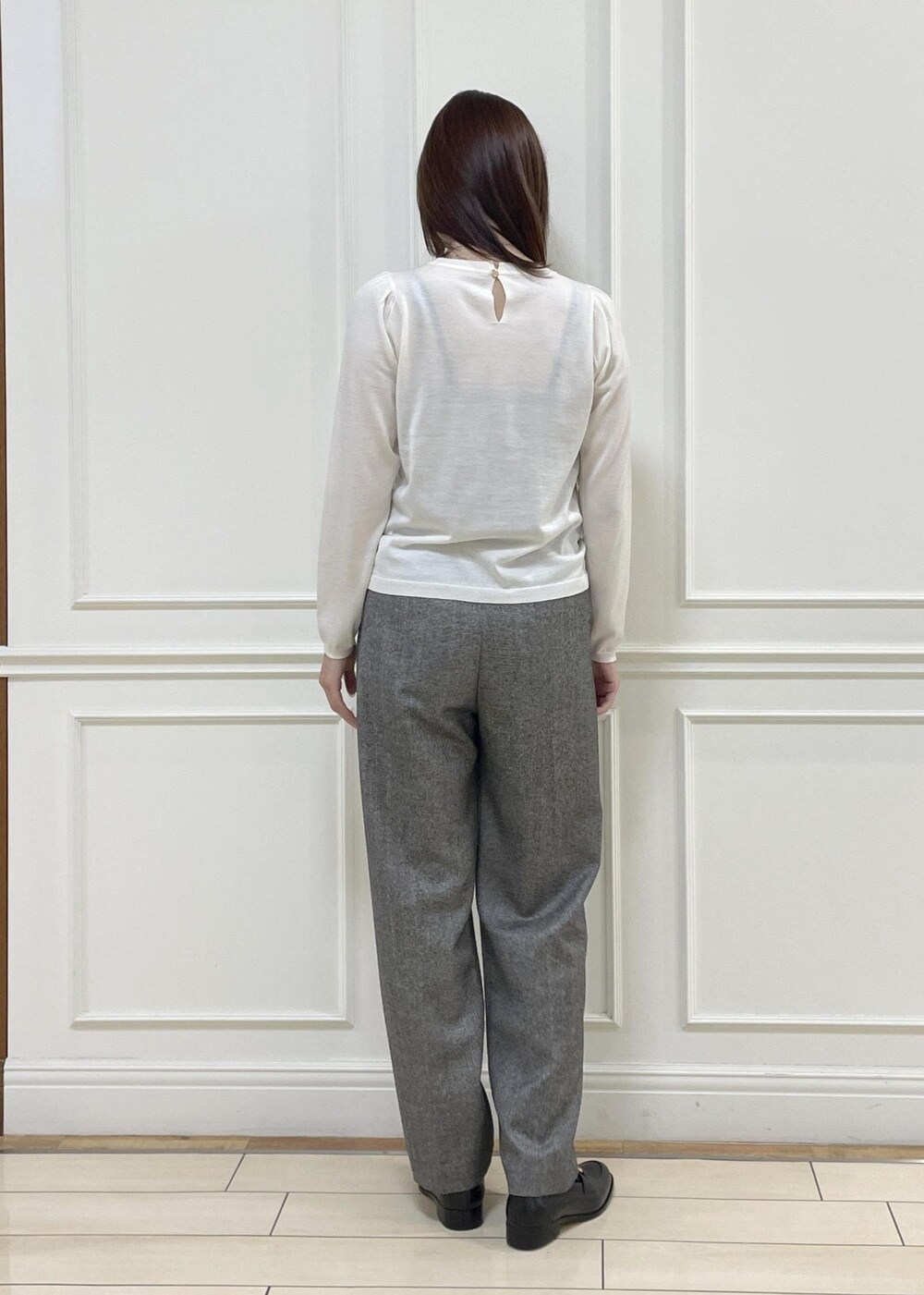 ホワイト系のハンドバッグ、ブラック系のローファー、ホワイト系のニット/セーターを着用したレディースの秋コーディネートの4枚目の写真