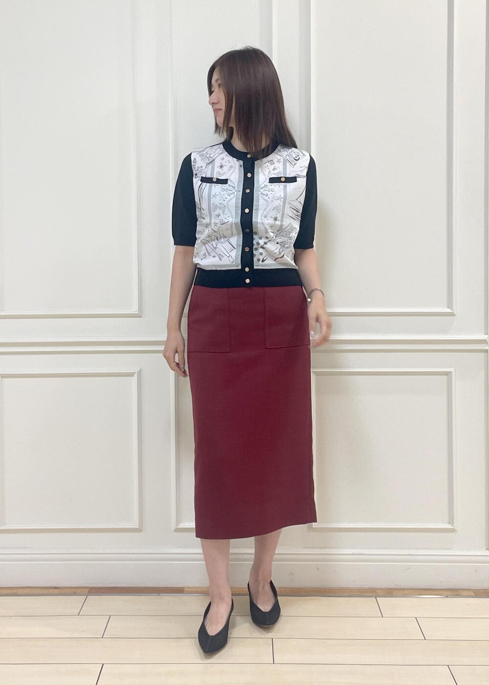 ブラック系のハンドバッグ、レッド系のスカート、ブラック系のシャツ/ブラウスを着用したレディースの夏コーディネートの2枚目の写真