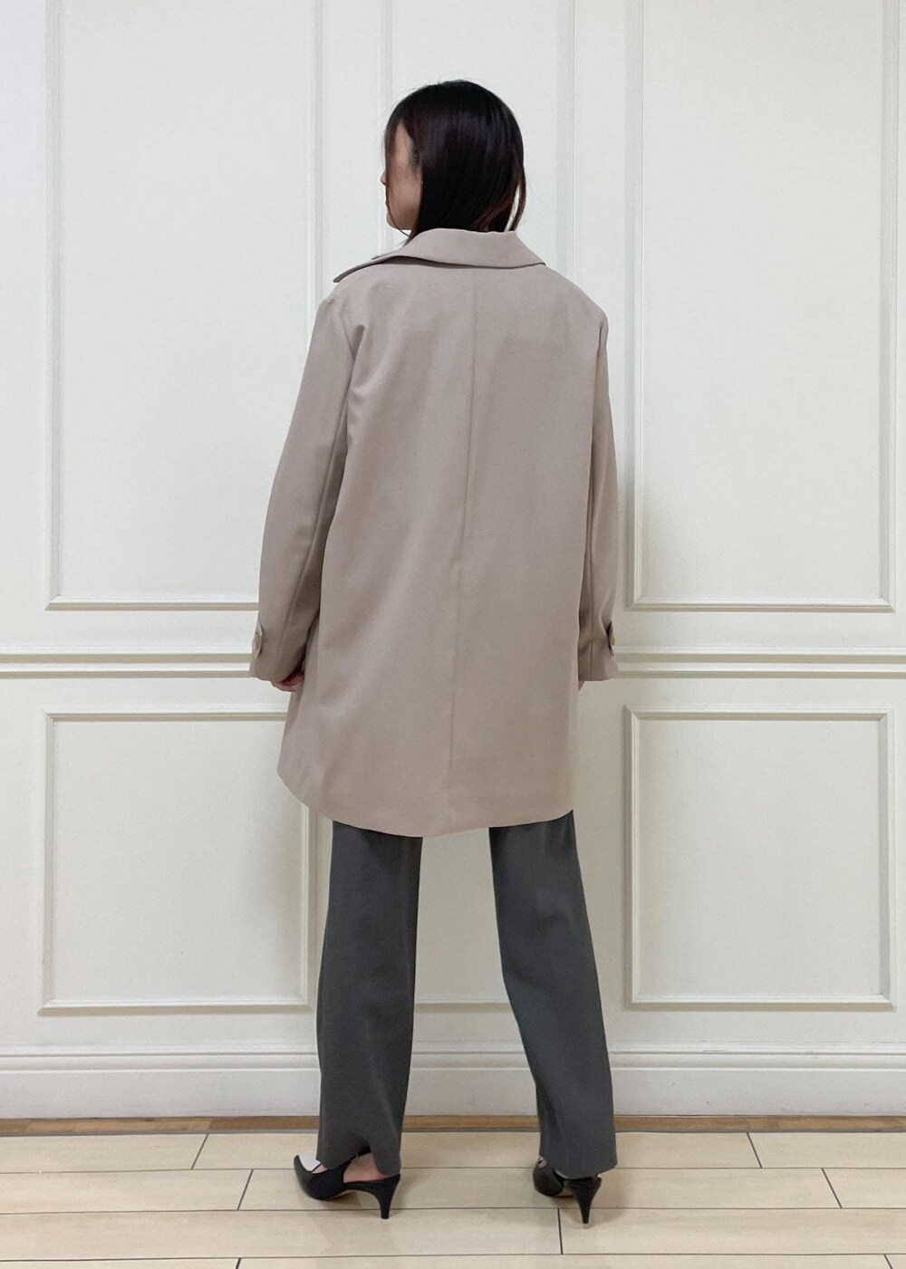 ブラック系のトートバッグ、ベージュ系のステンカラーコート、ブラック系のパンプスを着用したレディースの春コーディネートの3枚目の写真