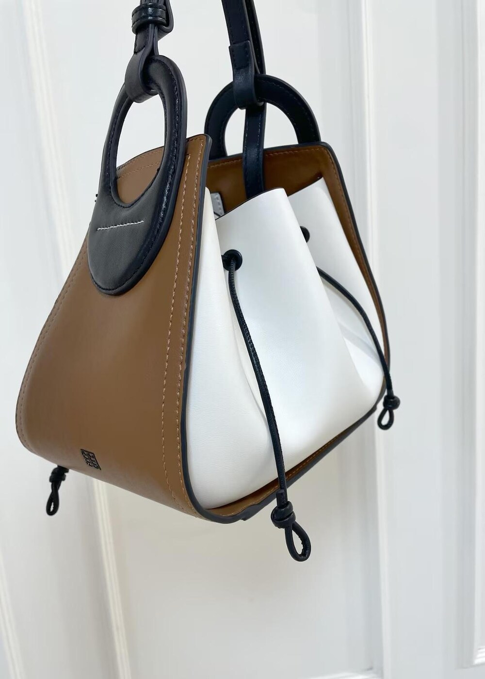 ホワイト系のショルダーバッグ、ブラック系のデニムパンツを着用したレディースの秋コーディネートの8枚目の写真