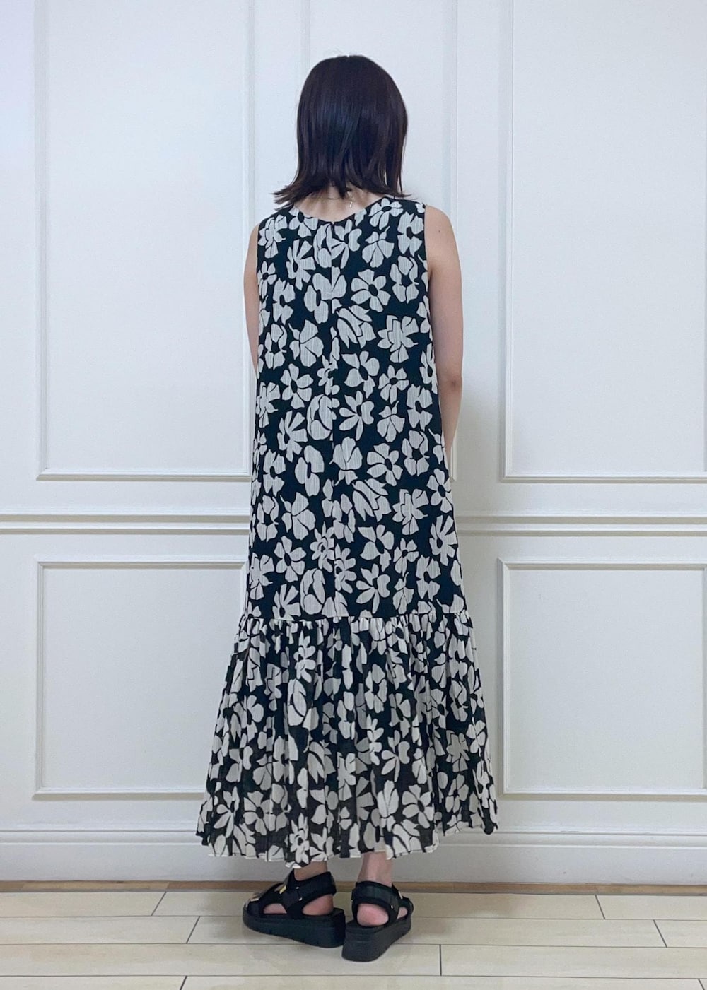 ブラック系のサンダル、ホワイト系のトートバッグ、ブラック系のワンピースを着用したレディースの夏コーディネートの3枚目の写真