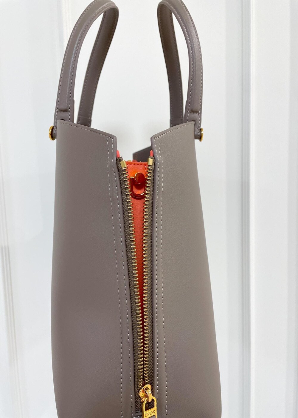 ブラウン系のトートバッグ、ベージュ系のテーラードジャケット、ブラック系のスカートを着用したレディースの夏コーディネートの10枚目の写真