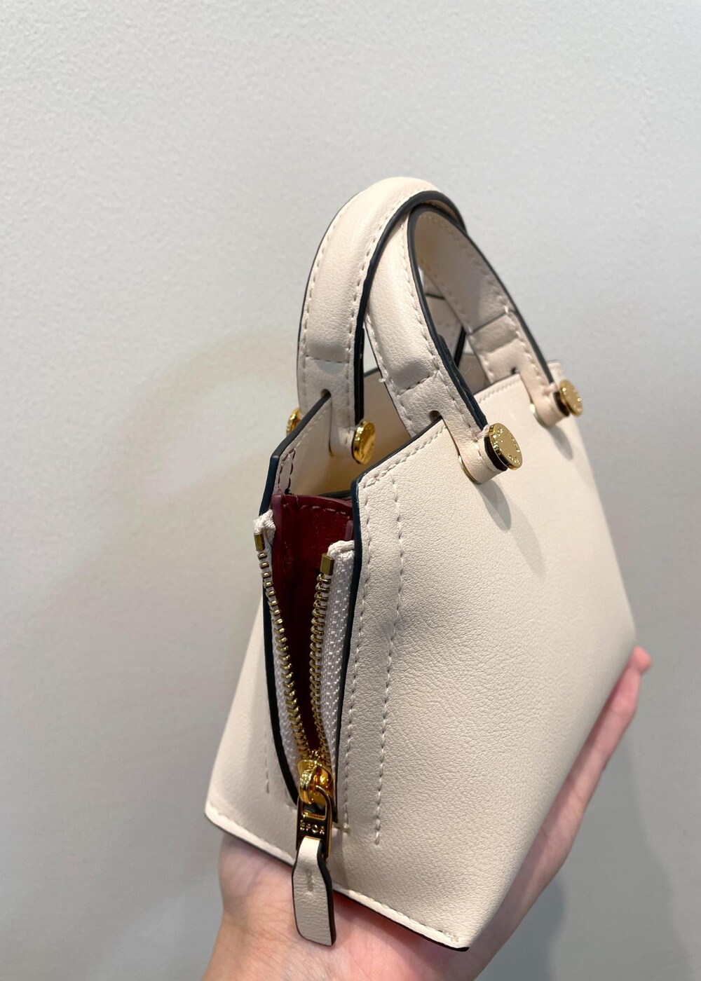 レッド系のタンクトップ、ベージュ系のショルダーバッグ、ブラック系のその他パンツを着用したレディースの夏コーディネートの7枚目の写真