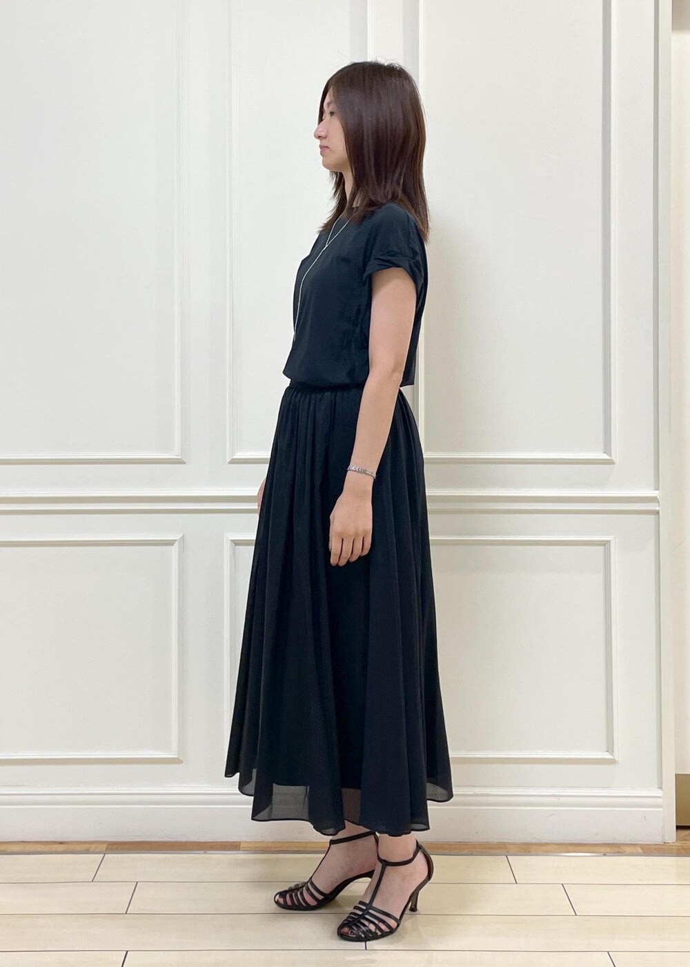 ブラウン系のトートバッグ、ベージュ系のテーラードジャケット、ブラック系のスカートを着用したレディースの夏コーディネートの6枚目の写真