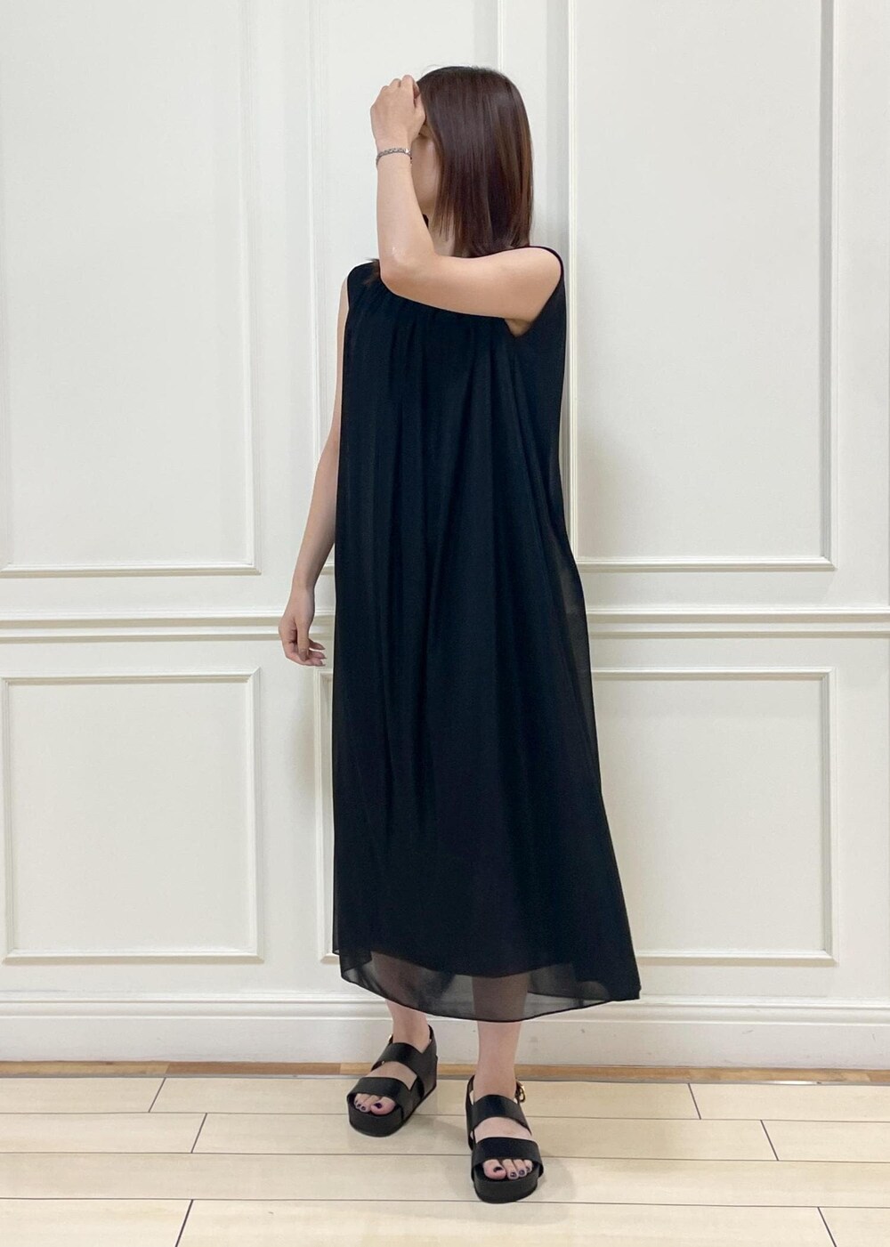 ブラック系のショルダーバッグ、ブラック系のサンダル、ブラック系のワンピースを着用したレディースの夏コーディネートの7枚目の写真