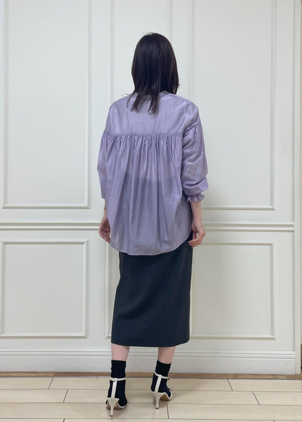 ホワイト系のハンドバッグ、ブラック系のスカート、ホワイト系のサンダルを着用したレディースの春コーディネートの4枚目の写真