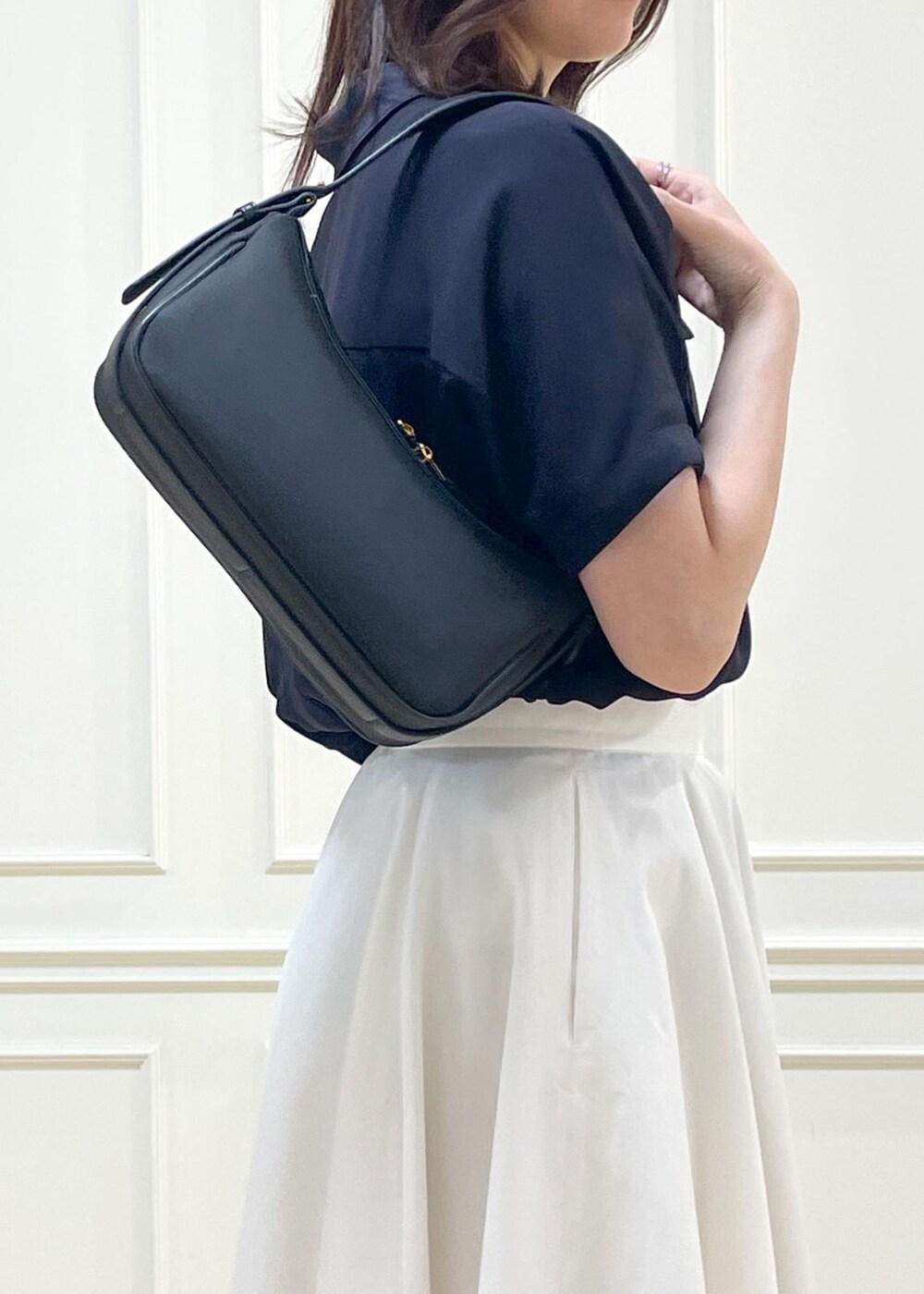 ブラック系のハンドバッグ、ホワイト系のスカート、ホワイト系のニット/セーターを着用したレディースの春コーディネートの8枚目の写真