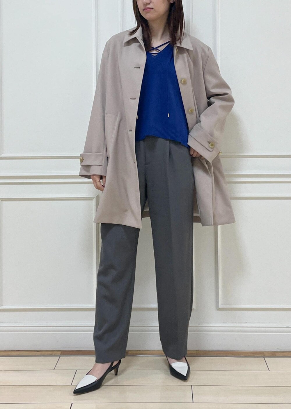 ブラック系のトートバッグ、ベージュ系のステンカラーコート、ブラック系のパンプスを着用したレディースの春コーディネートの5枚目の写真