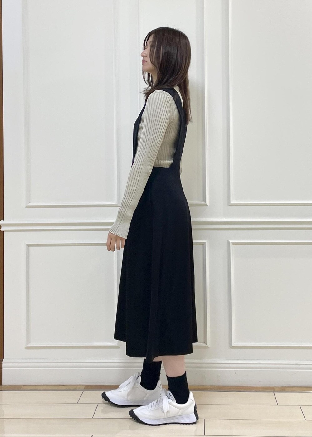 ブラック系のワンピース、ベージュ系のニット/セーター、イエロー系のハンドバッグを着用したレディースの秋コーディネートの3枚目の写真