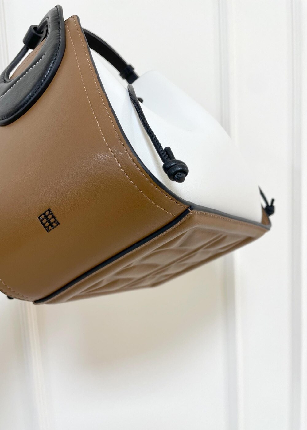 ブルー系のデニムパンツ、ホワイト系のハンドバッグ、ブルー系のノーカラージャケットを着用したレディースの秋コーディネートの9枚目の写真