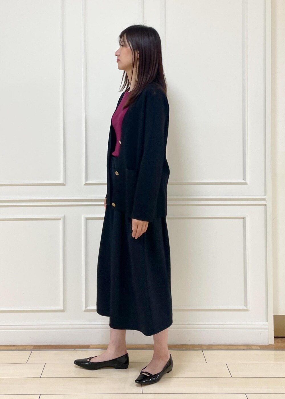 レッド系のタンクトップ、ベージュ系のショルダーバッグ、ブラック系のその他パンツを着用したレディースの夏コーディネートの2枚目の写真