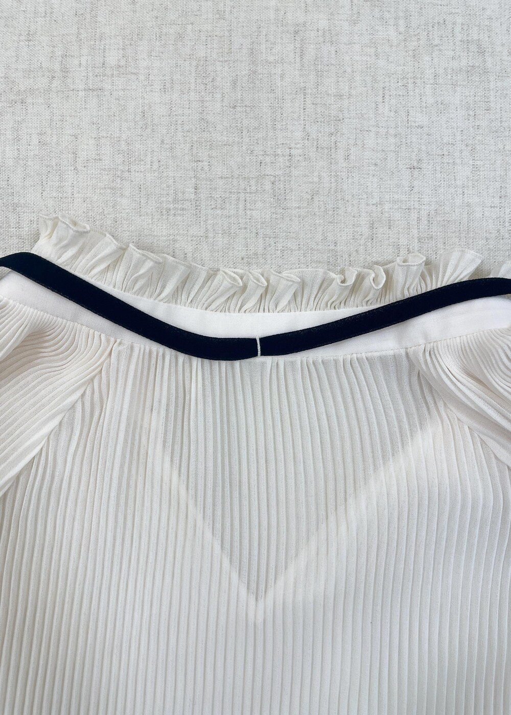 ホワイト系のショルダーバッグ、ブラック系のデニムパンツを着用したレディースの秋コーディネートの6枚目の写真