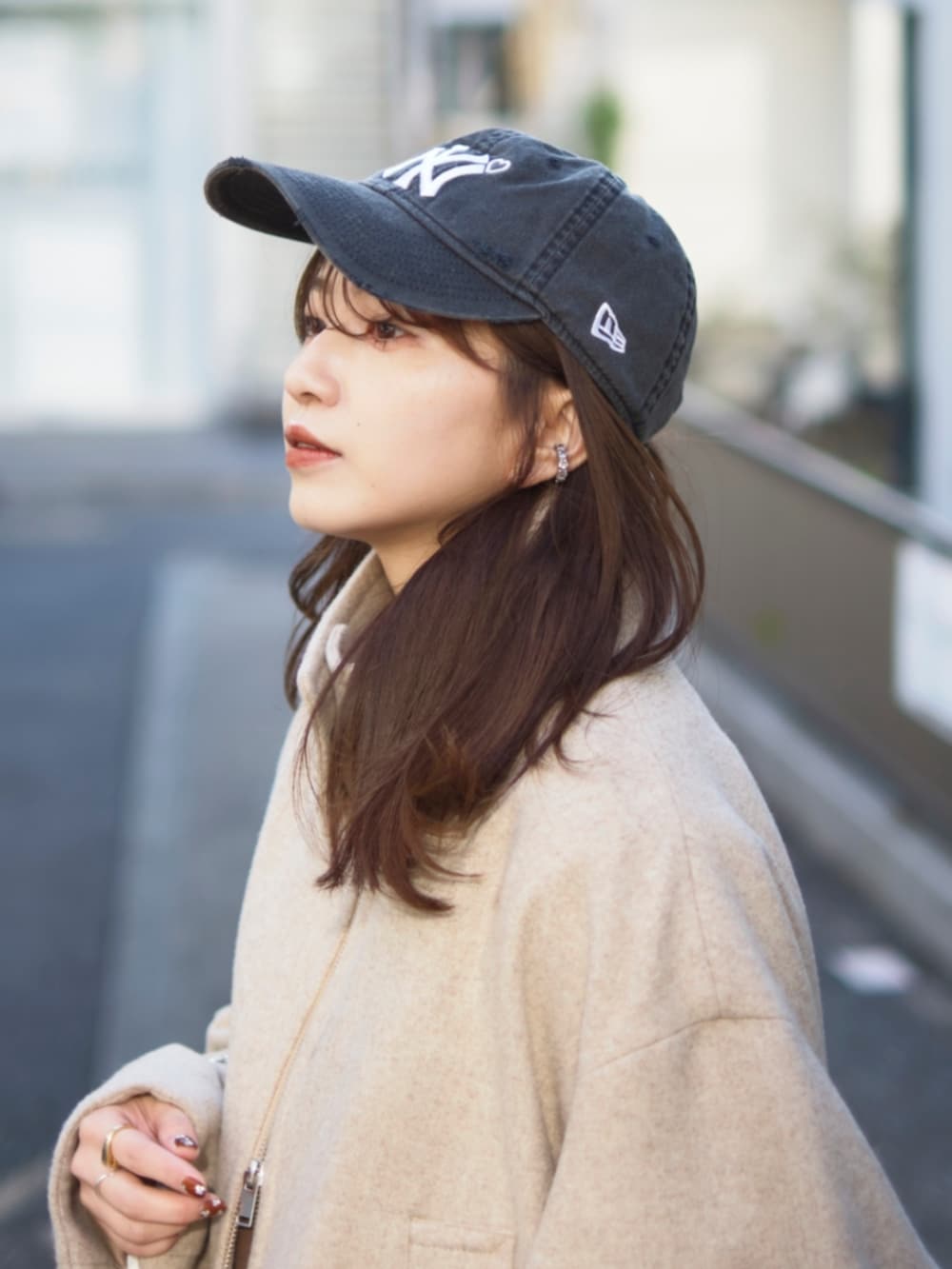 ブラック系のデニムスカート、ベージュ系のブルゾン、ブラック系のショルダーバッグを着用したレディースの冬コーディネートの2枚目の写真