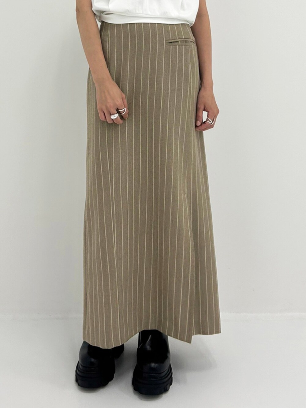 ベージュ系のスカート、ホワイト系のTシャツ/カットソーを着用したレディースの秋コーディネートの3枚目の写真