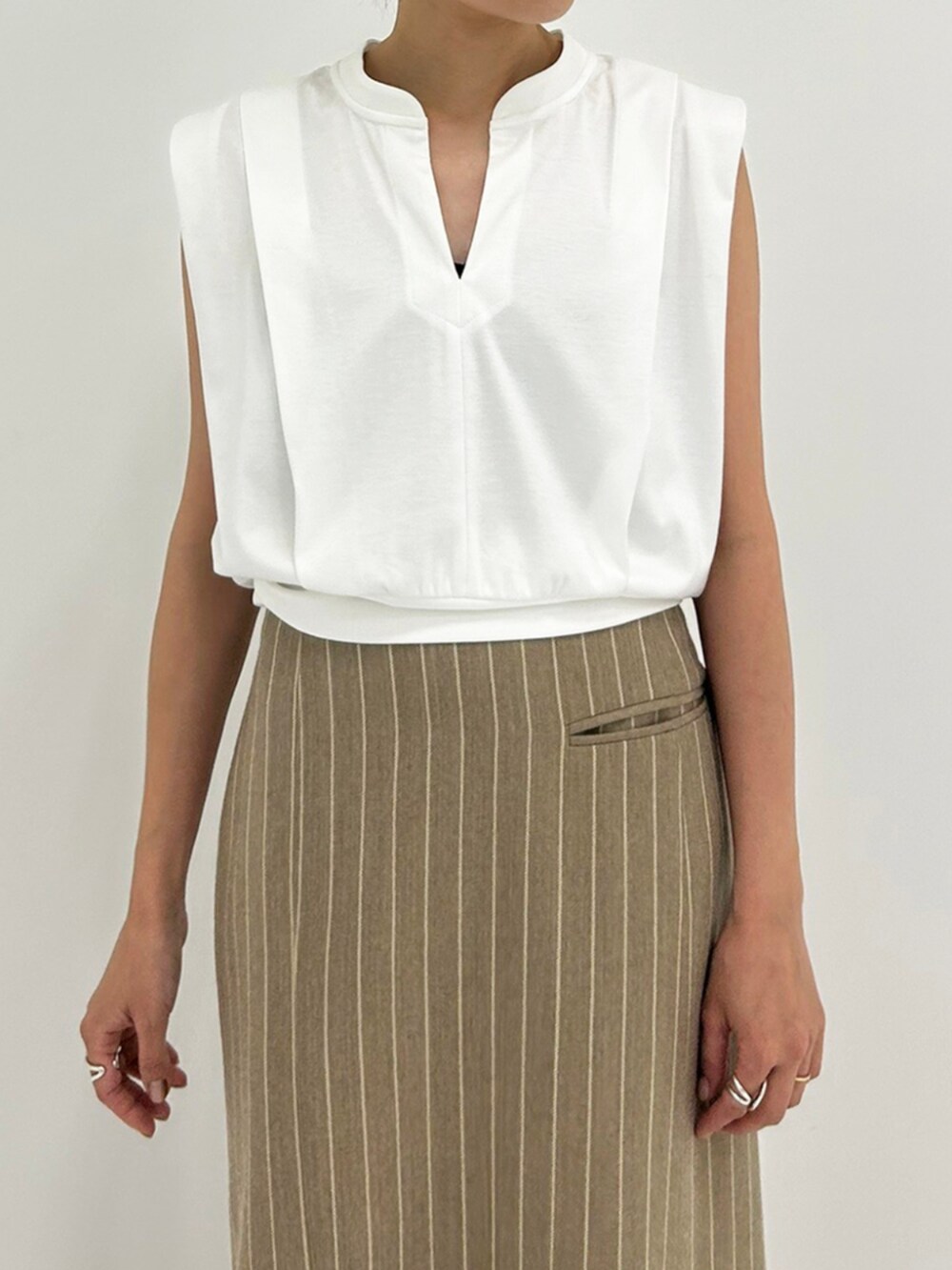 ベージュ系のスカート、ホワイト系のTシャツ/カットソーを着用したレディースの秋コーディネートの2枚目の写真