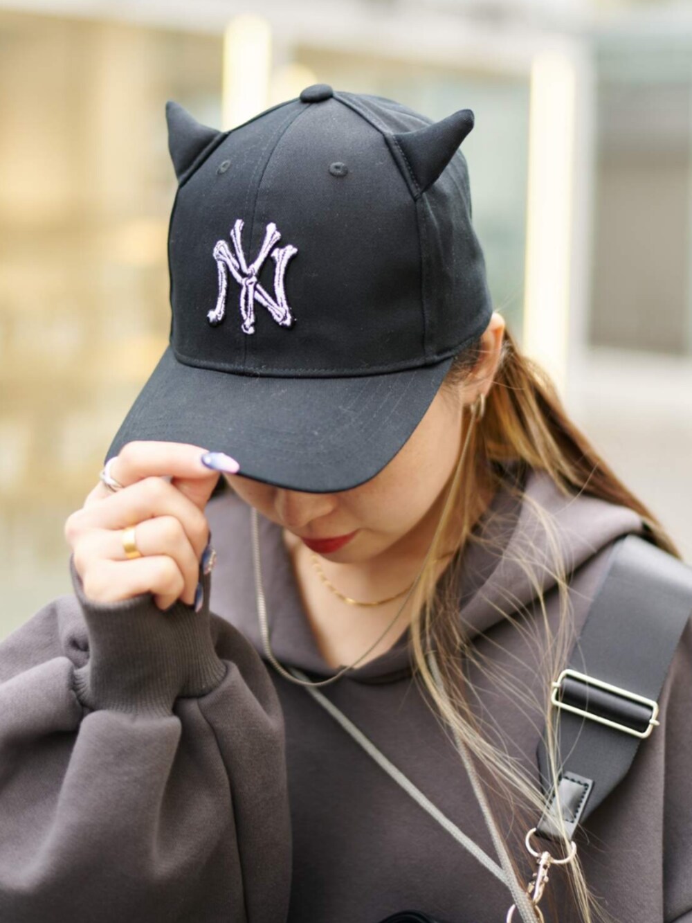 ベージュ系のスリッポン、グレー系のパーカー、ブラック系のキャップを着用したレディースの冬コーディネートの5枚目の写真