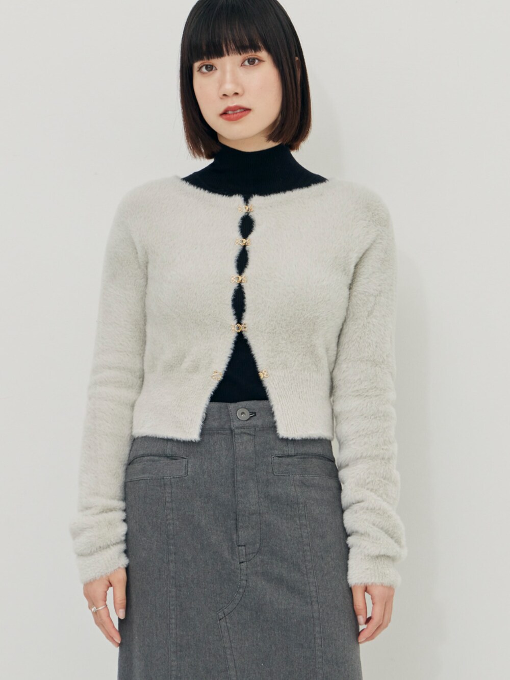 グレー系のカーディガン/ボレロ、ブラック系のニット/セーター、グレー系のスカートを着用したレディースの秋コーディネートの4枚目の写真