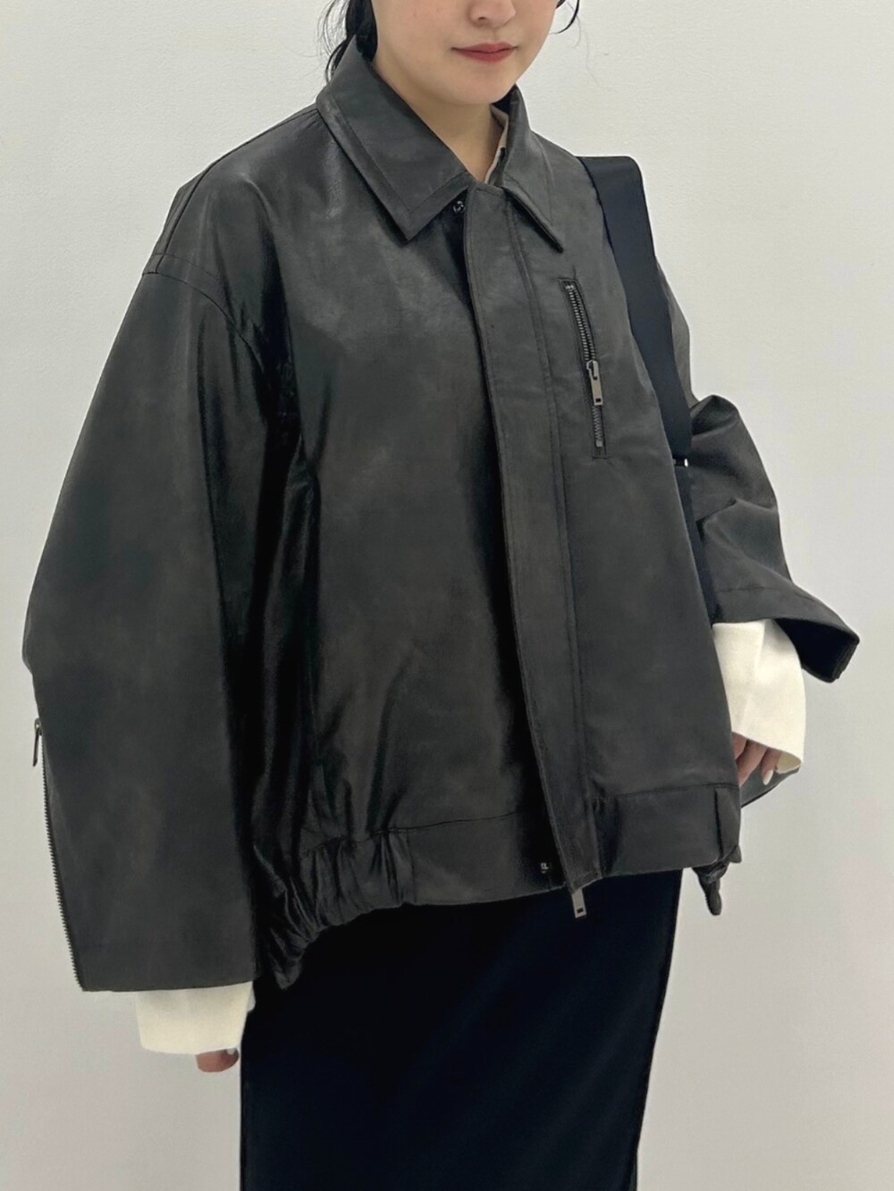 ブラウン系のブルゾン、ブラック系のショルダーバッグを着用したレディースの秋コーディネートの4枚目の写真