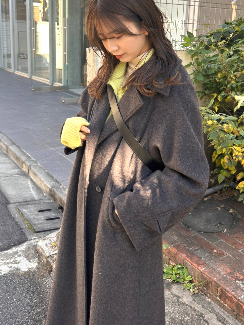 ブルー系のデニムパンツ、グリーン系のニット/セーター、グレー系のその他アウターを着用したレディースの秋コーディネートの4枚目の写真