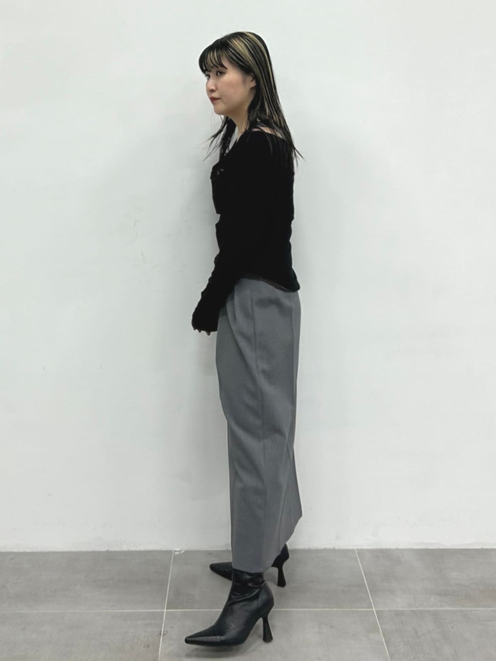 グレー系のタンクトップ、ブラック系のTシャツ/カットソー、グレー系のスカートを着用したレディースの秋コーディネートの2枚目の写真