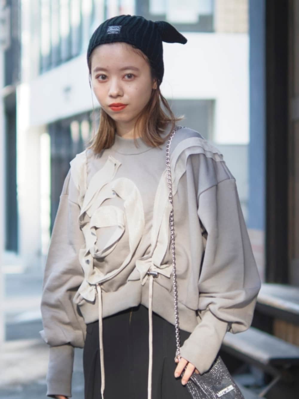 グレー系のスウェット、ブラック系のショルダーバッグ、ブラック系のニットキャップ/ビーニーを着用したレディースの冬コーディネートの2枚目の写真