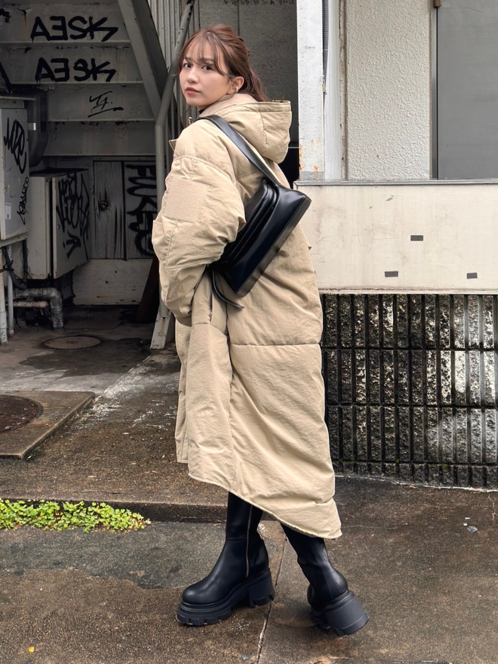 ブラック系のブーツ、グリーン系のダウンジャケット/コートを着用したレディースの秋コーディネートの2枚目の写真