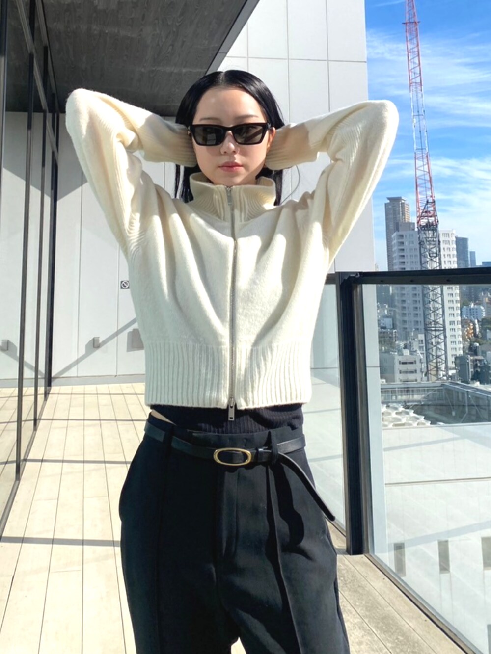 ブラック系のスラックス、ホワイト系のニット/セーターを着用したレディースの秋コーディネートの5枚目の写真