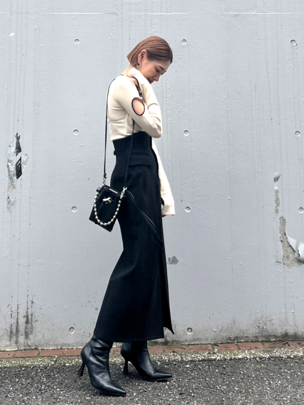 ブラック系のブーツ、ブラック系のスカートを着用したレディースの秋コーディネートの2枚目の写真