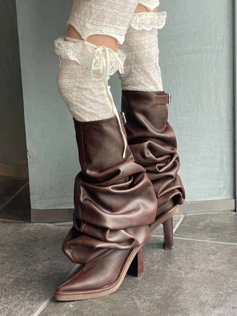 グレー系のテーラードジャケット、ブラウン系のブーツ、ピンク系のショルダーバッグを着用したレディースの秋コーディネートの2枚目の写真