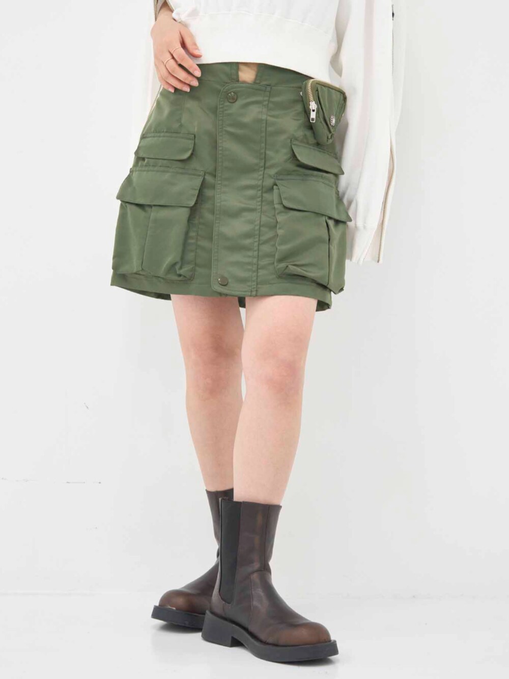 ホワイト系のパーカー、グリーン系のスカートを着用したレディースの冬コーディネートの7枚目の写真