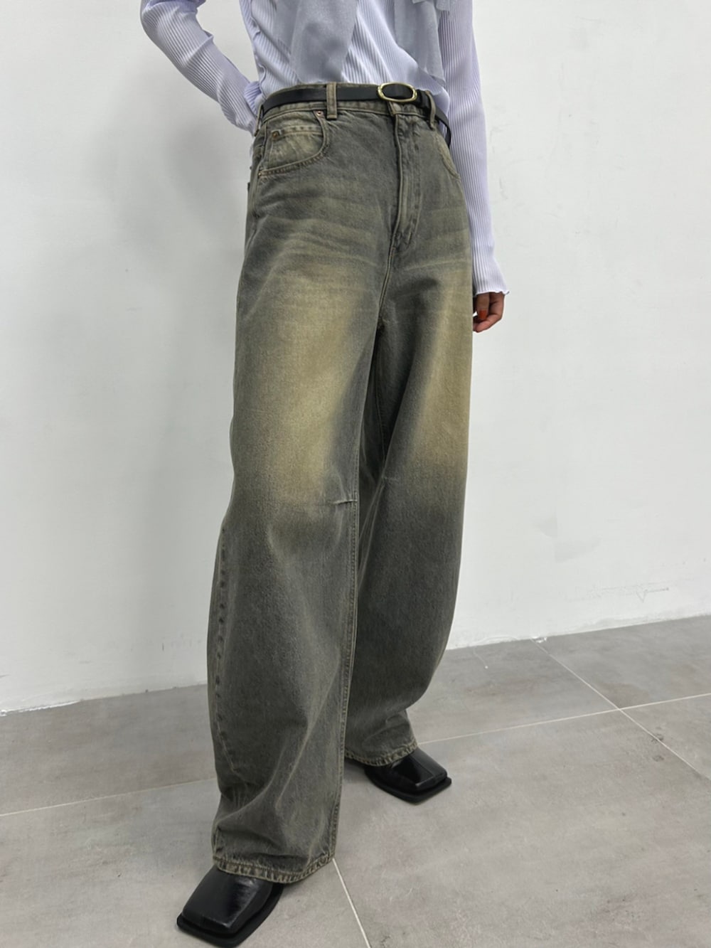 ブラック系のデニムパンツ、パープル系のTシャツ/カットソーを着用したレディースの秋コーディネートの3枚目の写真