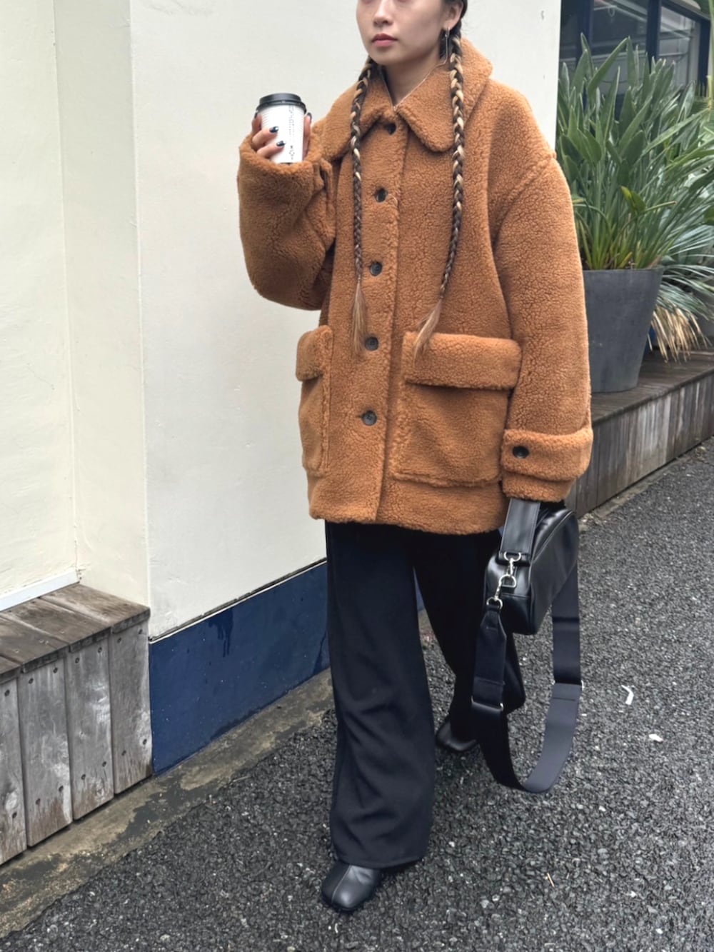 ベージュ系のその他アウター、ブラック系のショルダーバッグを着用したレディースの秋コーディネートの2枚目の写真